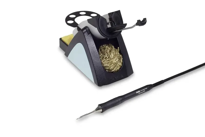 WT1010M's WSR 205 safety stand with iron holder, cleaning sponge and gold metal wool, next to the active-tip iron